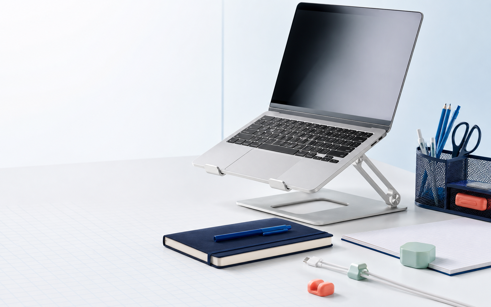 Organized modern desk with laptop stand and office supplies
